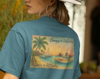 May include: Teal t-shirt featuring a tropical beach scene with palm trees, a sailboat, and a motorboat. The text "Changes in Latitudes, Changes in Attitudes" is printed above and below the image. The shirt is a solid teal color.