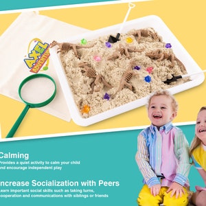 May include: A children's sensory play set with a white tray filled with sand, toy dinosaur skeletons, and colorful gems. A magnifying glass, a small shovel, and a canvas bag with the "AXEL ADVENTURE" logo are also included. Two smiling children are in the foreground.