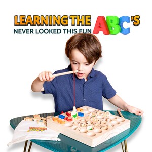 May include: A child plays with a wooden alphabet fishing game. The game board has cutouts for letters and small wooden fish. The text "LEARNING THE ABC'S NEVER LOOKED THIS FUN" is displayed above the child.