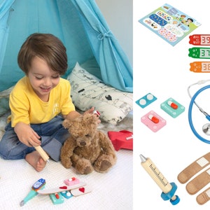 May include: A child plays doctor with a teddy bear using a toy stethoscope, thermometer, bandages, and pills. The play doctor set is made of wood and plastic.