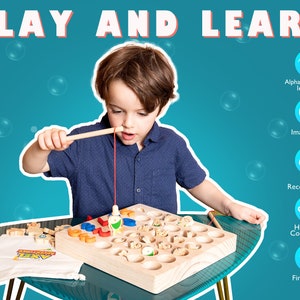 K&ouml;nnte beinhalten: Ein Kind spielt mit einem Angelspiel aus Holz. Das Spielbrett hat Aussparungen f&uuml;r Fische und Holzbl&ouml;cke. Das Bild enth&auml;lt den Text "PLAY AND LEARN" und Symbole f&uuml;r Alphabet, Vorstellungskraft, Farberkennung, Hand-Augen-Koordination und Feinmotorik.