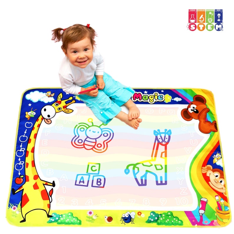 May include: A colorful, multi-purpose play mat with a giraffe, butterfly, and other animal illustrations. The mat features a white, erasable surface for drawing and learning. The text "Magic" is printed in yellow on the mat.