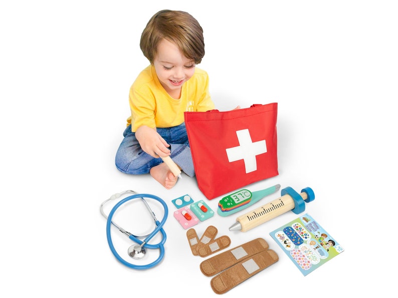 May include: A red medical bag with a white cross on it. The bag is open and contains a variety of medical supplies, including a stethoscope, a thermometer, a syringe, bandages, and pills. A child is playing doctor with the medical supplies.