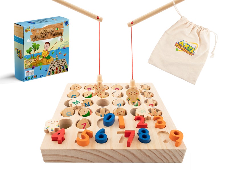 K&ouml;nnte beinhalten: Holz-Alphabet-Angelspiel mit hellbrauner Holzbasis, bunten Buchstaben, Zahlen und Meerestierformen. Enth&auml;lt zwei Angelruten aus Holz und einen Stoffbeutel mit dem Text "Axel Adventures". Auf der Box steht "Wooden Alphabet Fishing".