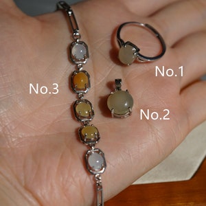 May include: A silver bracelet with five oval-shaped gemstones in shades of white, yellow, and orange.  A silver ring with a white oval-shaped gemstone. A silver pendant with a white oval-shaped gemstone. The items are labeled No. 3, No. 2, and No. 1.
