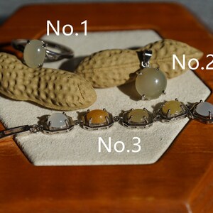 May include: Three silver jewelry pieces with white and yellow gemstones. The first piece is a ring labeled "No. 1", the second is a pendant labeled "No. 2", and the third is a bracelet labeled "No. 3".