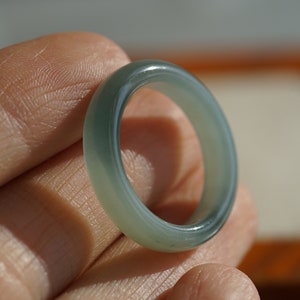 May include: A light green jade ring with a smooth, polished finish.
