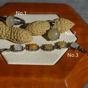 May include: Three pieces of jewelry with white and yellow stones set in silver. The jewelry includes a ring, a pendant, and a bracelet. The ring is labeled "No. 1", the pendant is labeled "No. 2", and the bracelet is labeled "No. 3".