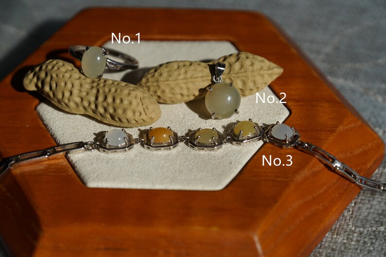 May include: Three pieces of jewelry with white and yellow stones set in silver. The jewelry includes a ring, a pendant, and a bracelet. The ring is labeled "No. 1", the pendant is labeled "No. 2", and the bracelet is labeled "No. 3".