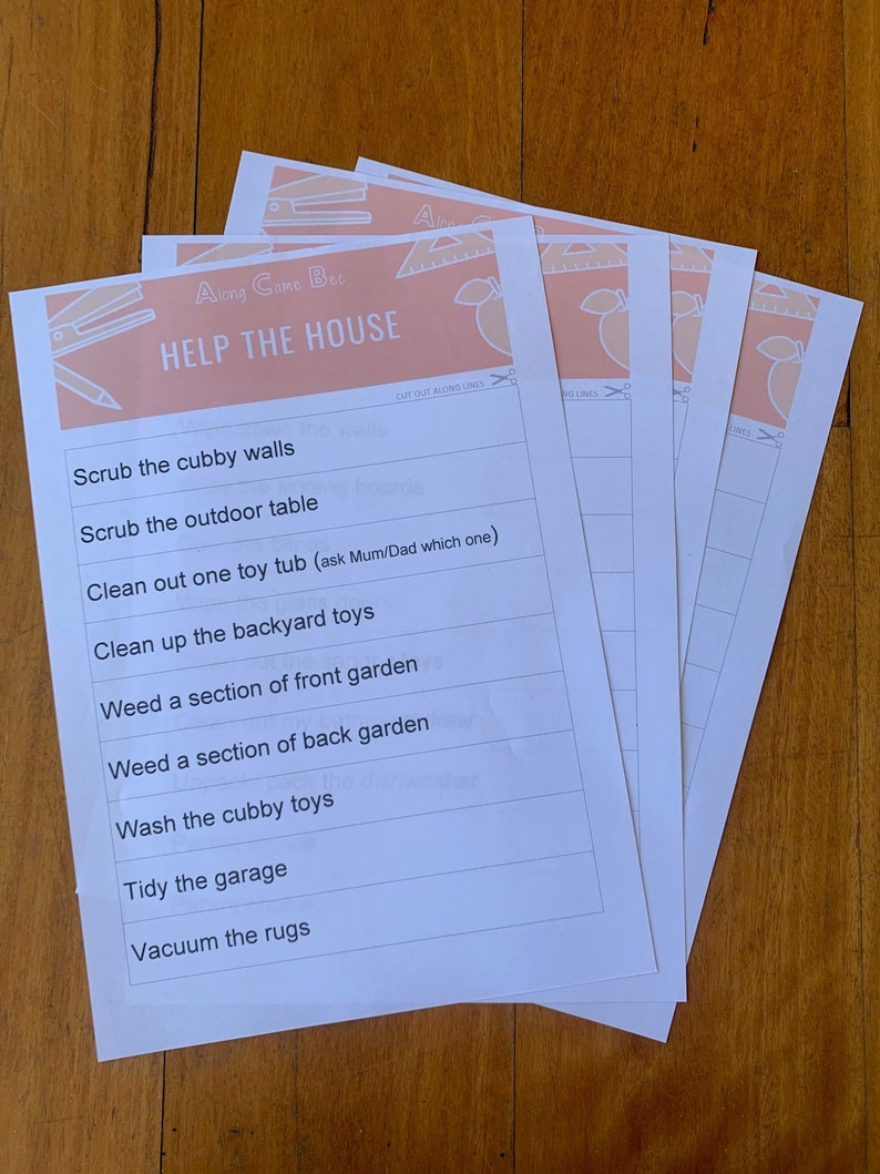 May include: Several white paper sheets with the text "HELP THE HOUSE" and a list of chores. The top of the sheets have a peach-colored banner with illustrations of a pencil, ruler, and other school supplies. The sheets are stacked on a wooden surface.