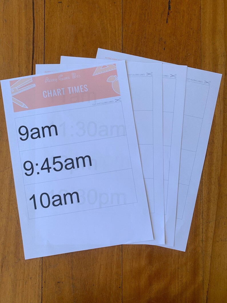 May include: A stack of white paper sheets with the text "Along Came Bee CHART TIMES" in peach and black. The sheets have time slots printed on them, including 9am, 9:45am, and 10am. The sheets are on a wooden surface.