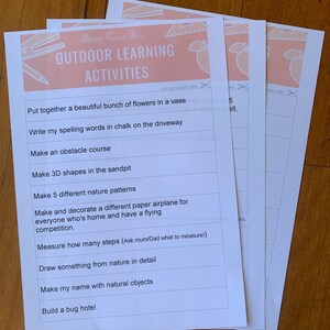 May include: Three white sheets of paper with the text "Along Came Bec OUTDOOR LEARNING ACTIVITIES" in peach and white. The sheets contain a list of outdoor activities, including making a bug hotel and drawing from nature.