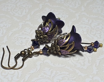 May include: Purple flower-shaped earrings with gold accents and dangling crystal beads.