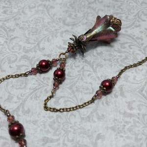 Crimson red and bronze gothic necklace. This handmade vintage style bronze necklace has a central flower drop that has been hand painted in colour shifting red and gold. Vibrant red glass pearls and burgundy crystals are added along the bronze tone chain. Whimsigoth jewelry, Fairytale fantasy necklace.