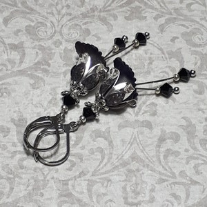 Gothic black vintage fairy flower earrings, delicate fluted flowers have been been paired with antique silver filigree floral bead caps. Jet black crystals are added to crystal drops that sway as the earrings move. Finished with lever back hooks.
