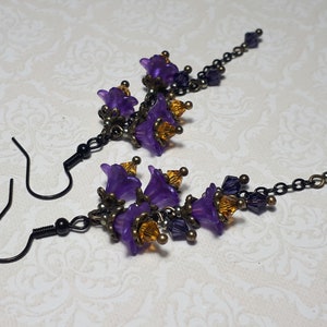 Handmade long chain dangle earrings with multi small purple flowers with yellow crystal centres and deep purple crystal droplets. Black chain and earring hooks. Bohemian Witchy Jewellery, Gift for goth, Gothic Floral Dangles,