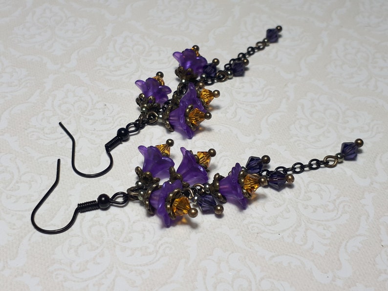 Handmade long chain dangle earrings with multi small purple flowers with yellow crystal centres and deep purple crystal droplets. Black chain and earring hooks. Bohemian Witchy Jewellery, Gift for goth, Gothic Floral Dangles,