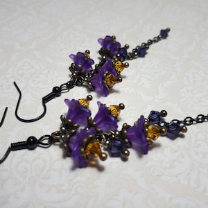 Handmade long chain dangle earrings with multi small purple flowers with yellow crystal centres and deep purple crystal droplets. Black chain and earring hooks. Bohemian Witchy Jewellery, Gift for goth, Gothic Floral Dangles,