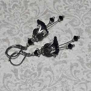 Gothic black vintage fairy flower earrings, delicate fluted flowers have been been paired with antique silver filigree floral bead caps. Jet black crystals are added to crystal drops that sway as the earrings move. Finished with lever back hooks.