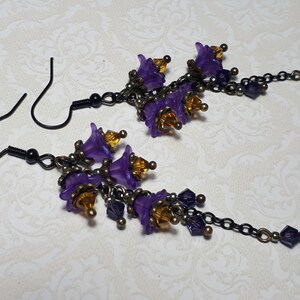 Handmade long chain dangle earrings with multi small purple flowers with yellow crystal centres and deep purple crystal droplets. Black chain and earring hooks. Bohemian Witchy Jewellery, Gift for goth, Gothic Floral Dangles,