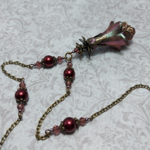 Crimson red and bronze gothic necklace. This handmade vintage style bronze necklace has a central flower drop that has been hand painted in colour shifting red and gold. Vibrant red glass pearls and burgundy crystals are added along the bronze tone chain. Whimsigoth jewelry, Fairytale fantasy necklace.