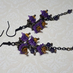 Handmade long chain dangle earrings with multi small purple flowers with yellow crystal centres and deep purple crystal droplets. Black chain and earring hooks. Bohemian Witchy Jewellery, Gift for goth, Gothic Floral Dangles,