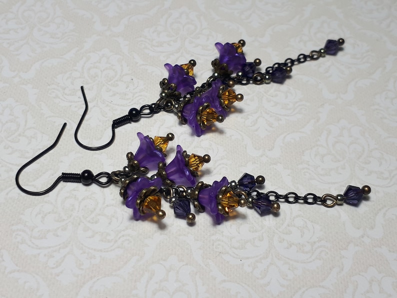Handmade long chain dangle earrings with multi small purple flowers with yellow crystal centres and deep purple crystal droplets. Black chain and earring hooks. Bohemian Witchy Jewellery, Gift for goth, Gothic Floral Dangles,