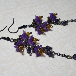 Handmade long chain dangle earrings with multi small purple flowers with yellow crystal centres and deep purple crystal droplets. Black chain and earring hooks. Bohemian Witchy Jewellery, Gift for goth, Gothic Floral Dangles,