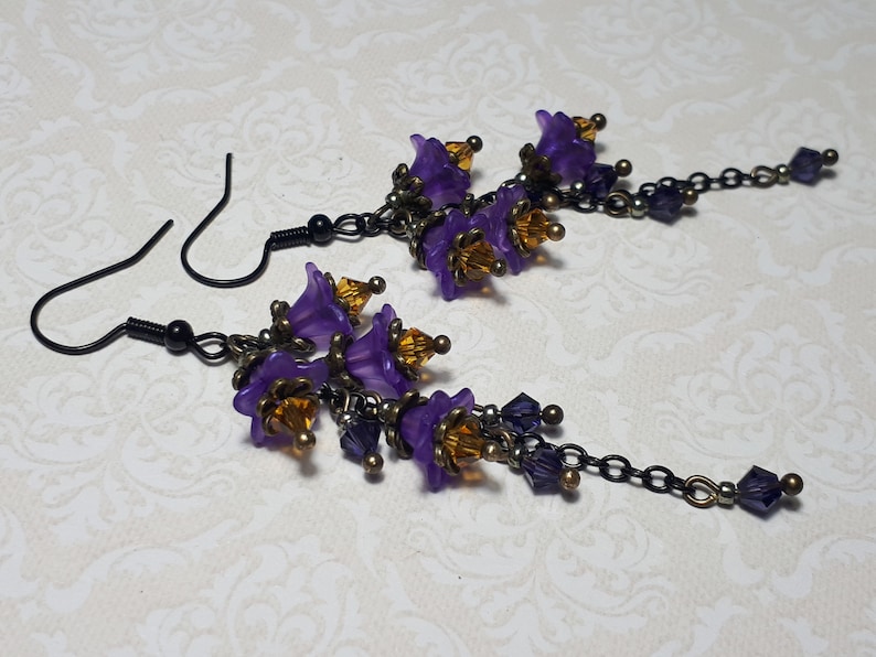 Handmade long chain dangle earrings with multi small purple flowers with yellow crystal centres and deep purple crystal droplets. Black chain and earring hooks. Bohemian Witchy Jewellery, Gift for goth, Gothic Floral Dangles,