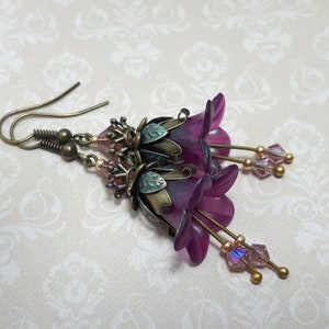 Mulberry purple bell flowers that have been hand painted with an iridescent green shimmer. They have antique bronze floral accents and light amethyst AB crystal drops from the bottoms of the flowers. They are fantasy vintage art nouveau in style.