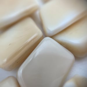 Könnte beinhalten: Nahaufnahme einer Gruppe glatter, cremefarbener, rechteckiger Fliesen. Die Fliesen sind in einem zufälligen Muster angeordnet.