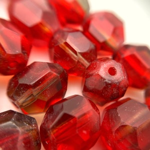 Cuentas de cristal checo talladas en forma ovalada, facetadas, con toques de rojo baya y marrón (9 x 10 mm) (RCG104)