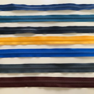 May include: Assortment of seven zipper closures in various colors, including navy blue, teal, black, yellow, royal blue, dark gray, and burgundy.