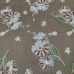 May include: A brown fabric with a white and brown floral pattern. The flowers are stylised and have a delicate, almost faded look.