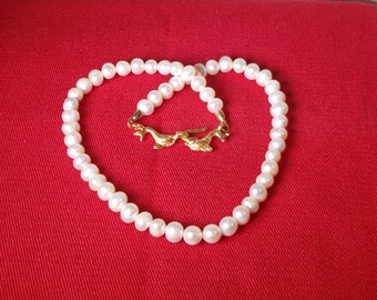 Estuarine pearl necklace and antique style clasp with dolphins. Brass material with 24k gold bath, nickel free.