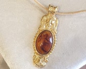 Cord necklace with antique style pendant and amber set. With particular and elegant closure of Dolphins.