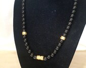 Onyx Stones necklace with antique style details, bathed in 24k gold.