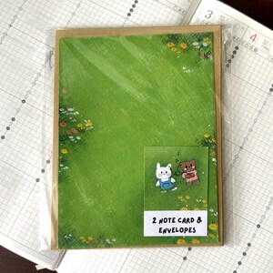 Tarjetas de campo de flores y hierba con sobres