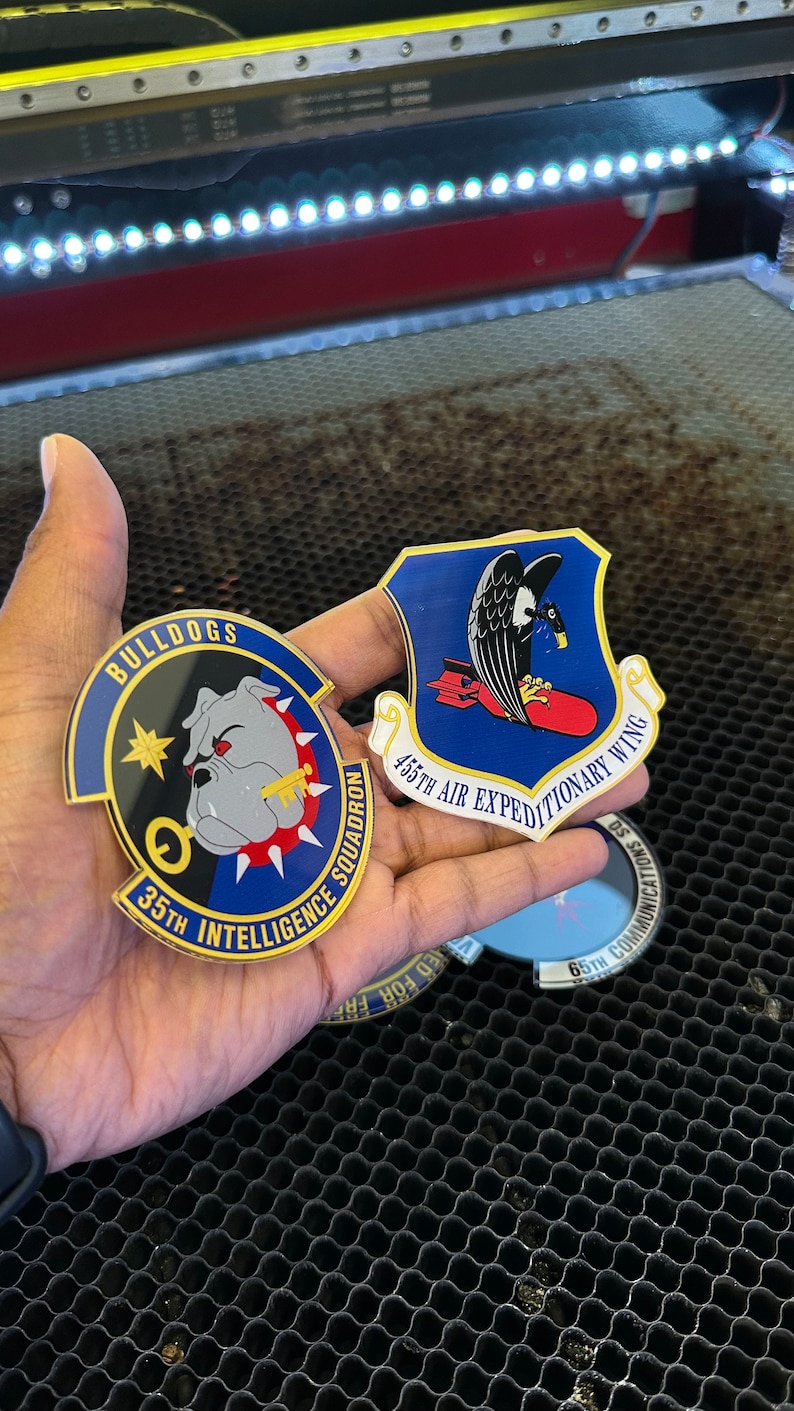 May include: Two military patches, one blue with a bulldog and the text "BULLDOGS 35TH INTELLIGENCE SQUADRON", and the other blue with a black bird and the text "455TH AIR EXPEDITIONARY WING".