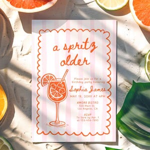May include: A birthday party invitation with a pink and white striped background, featuring the text "a spritz older" and a cocktail illustration. The invitation is surrounded by citrus fruits and tropical leaves.