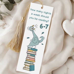 Pode incluir: Marcador de livros branco com um desenho de pombo de desenho animado em cima de uma pilha de livros. O texto diz: "quantas noites por semana você deve ler?" e "6-7". O marcador tem uma borla dourada.