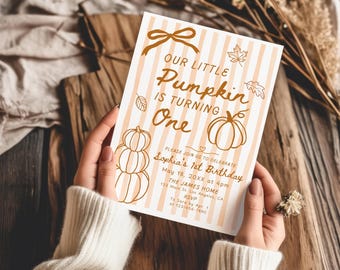 May include: A rectangular birthday invitation card featuring a light orange and white vertical striped background with brown line art of pumpkins, leaves, and a bow. The text reads: Our Little Pumpkin Is Turning One, Sophia's 1st Birthday.