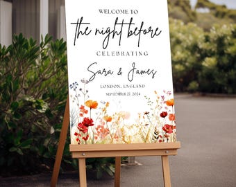 May include: A white rectangular wedding welcome sign on a wooden easel featuring the text "WELCOME TO The night before CELEBRATING Sara & James LONDON, ENGLAND SEPTEMBER 27, 2024" above a colorful watercolor illustration of wildflowers.
