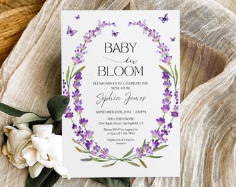 May include: A rectangular white baby shower invitation card featuring a watercolor lavender wreath and small purple butterflies. The text reads BABY IN BLOOM, PLEASE JOIN US TO CELEBRATE THE MOM TO BE, Sophia James, SEPTEMBER 25TH, 20XX, 2:30PM, THE JAMES HOME, 1234 Maple Street, Springfield, CA, Please RSVP by August 1st to Sara 123-456-7890, Registered at Target & Amazon.