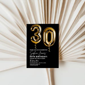 May include: Black and white birthday invitation with gold foil 30th birthday balloons. The invitation reads "Please join us in celebrating Sophia James' 30th Birthday!" with the date and time of the event.