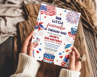 May include: A rectangular birthday invitation card featuring red, white, and blue watercolor illustrations of an American flag, fireworks, a cupcake, a cake, and a top hat. The text reads: Our little firecracker is turning one! Jacob's 2nd birthday.