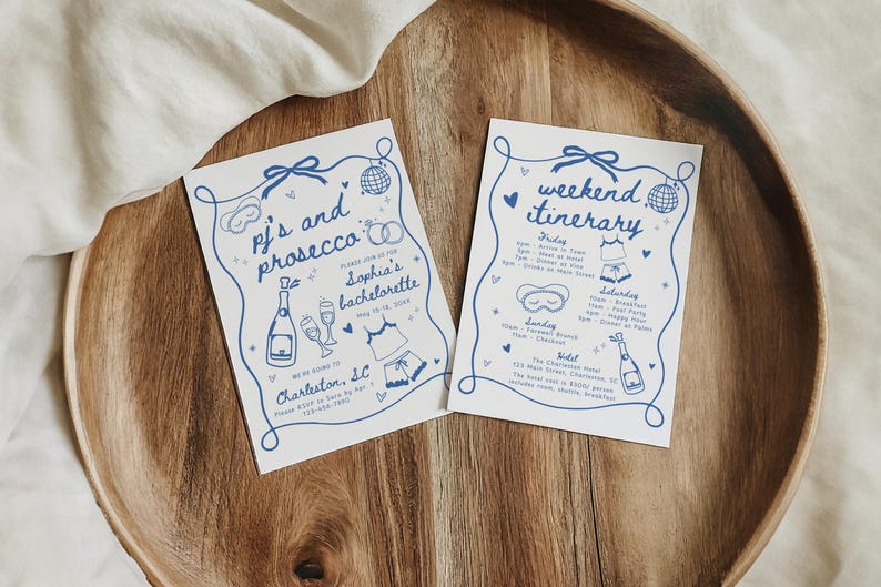 May include: Two white cards with blue illustrations and text. The first card says "pj's and prosecco" and the second card says "weekend itinerary".