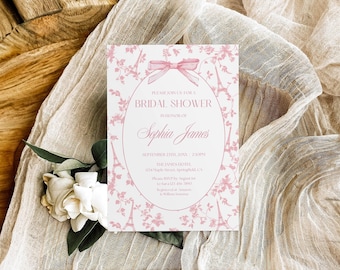 Puede incluir: Una tarjeta de invitación rectangular para despedida de soltera con un patrón rosa de la Torre Eiffel y flores, un marco ovalado central, un gráfico de lazo rosa y texto que incluye "BRIDAL SHOWER", "Sophia James" y detalles del evento.