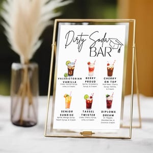 May include: A gold-framed sign with the words "Dirty Soda BAR" and illustrations of six soda drink recipes. The recipes include ingredients like vanilla syrup, cherry syrup, and cream. A graduation cap graphic is at the top.