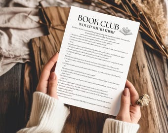 May include: A white paper sheet featuring the black text Book Club Would You Rather, followed by a list of twenty numbered questions for group discussion, with a small line drawing of an open book with flowers at the top right corner.